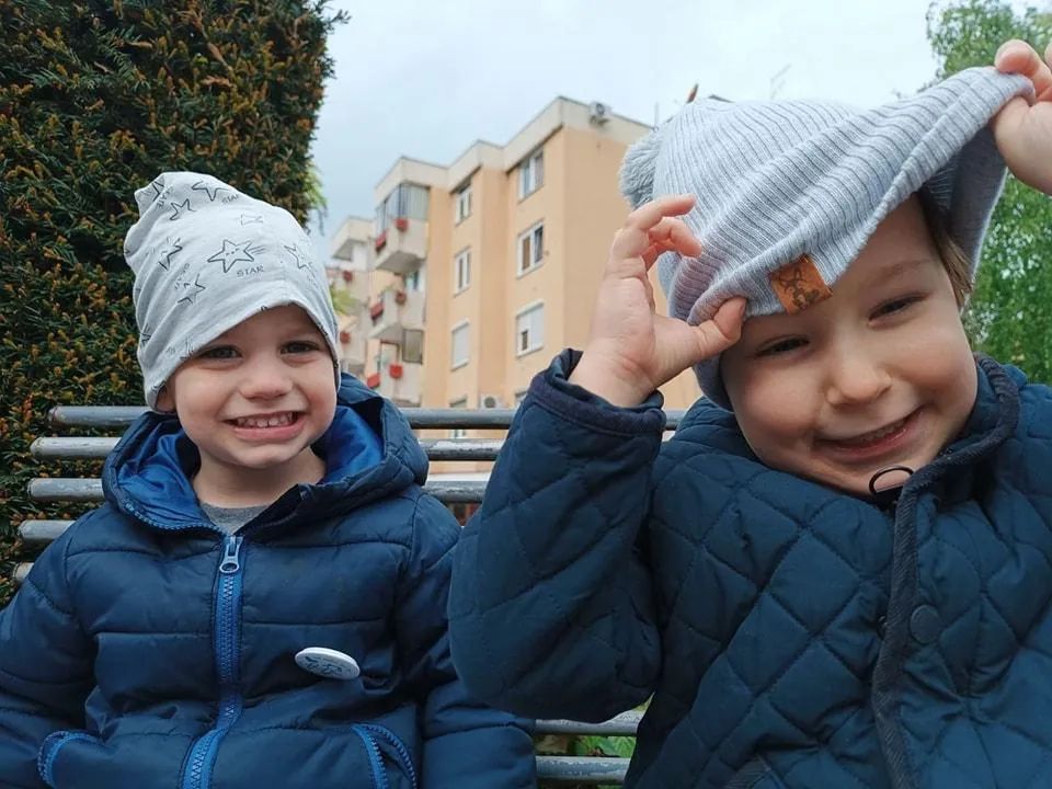 Dva dječaka Vrtića Ću-Ću u zimskim kapama, zgrade Alipašinog Polja iza njih