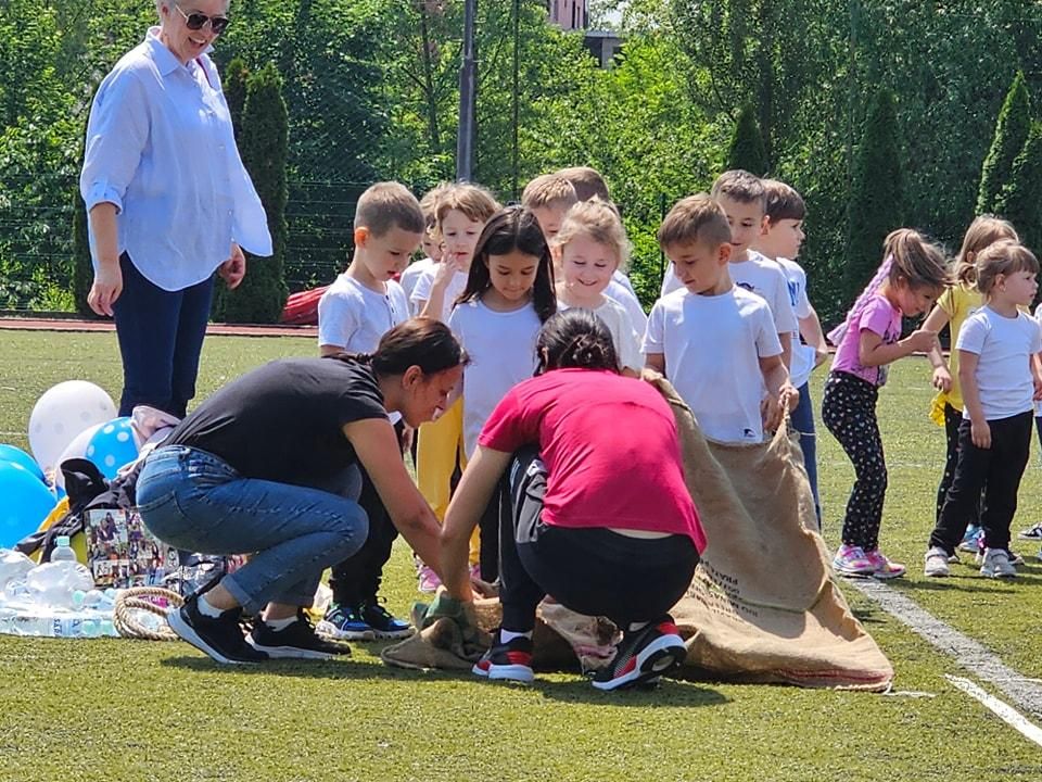 Trka u vrećama na sportskom danu Vrtića Ću-Ću, odgajateljica pomaže djeci