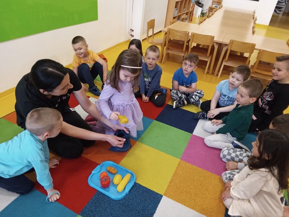 Odgajateljica Vrtića Ću-Ću i djeca u krugu na šarenom tepihu