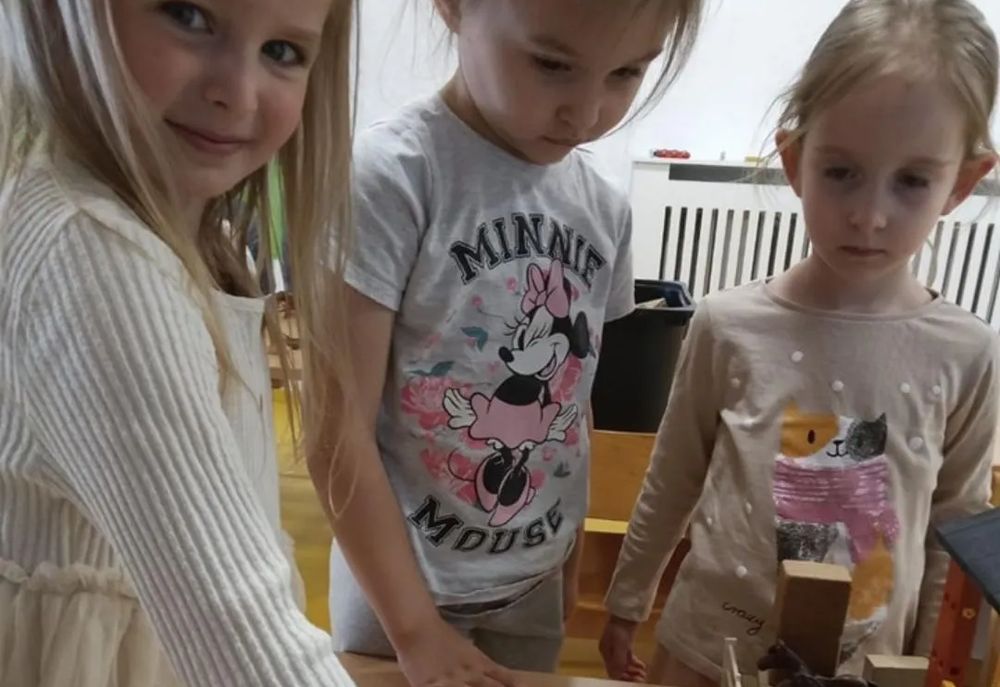 Troje djece Vrtića Ću-Ću za stolom s drvenim didaktičkim igračkama